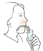 Woman inhaling medication from nebulizer with mouthpiece.