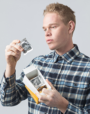 Un hombre sostiene una caja de preservativos.